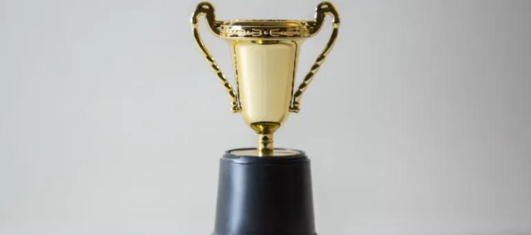 Small golden plastic trophy on a black stand