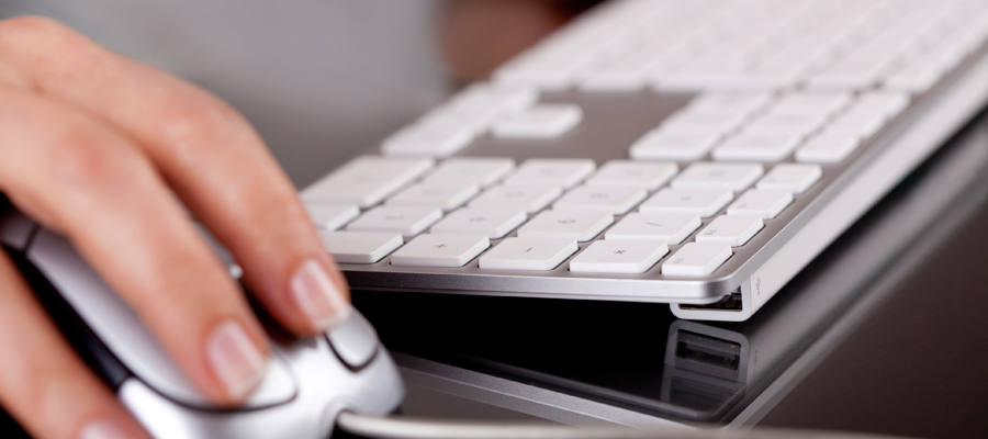 Hand using computer mouse and keyboard